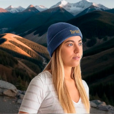 Una mujer con un gorro con un logo en una montaña